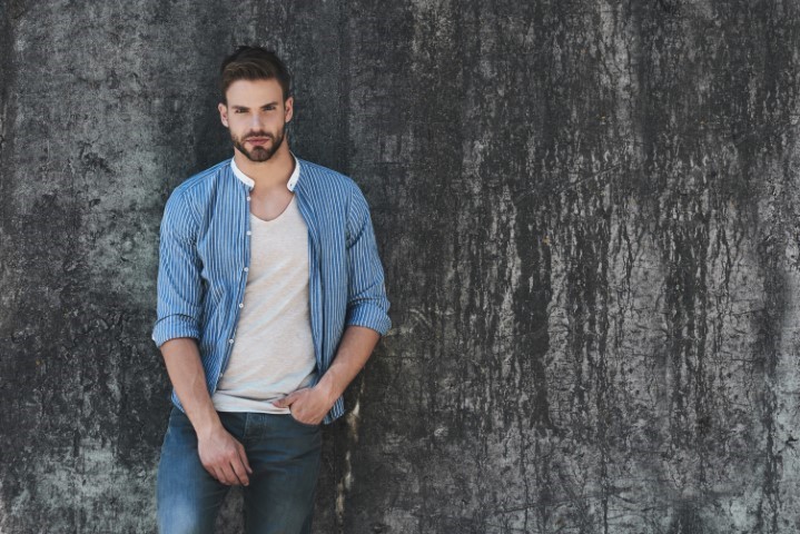Full length portrait of young handsome model dressed in casual outfit and looking away.